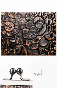 Detalle de la textura floral en relieve y el cierre metálico de un bolso de mano rojo