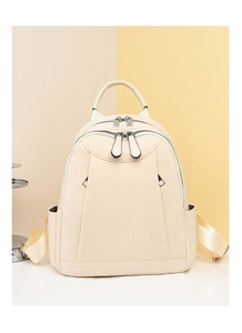 Front detail of a cream faux leather backpack with silver hardware and front pocket