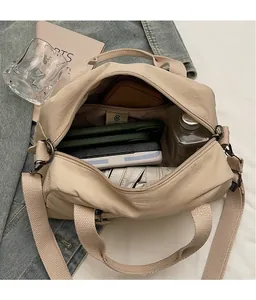 Top view of beige large capacity crossbody bag interior with multiple compartments and items
