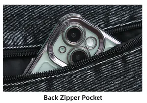 Close-up of a denim crossbody bag showing the back zipper pocket with a smartphone inside