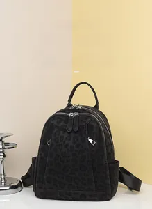 Detail of black leopard print backpack with metal zippers and nylon shoulder straps