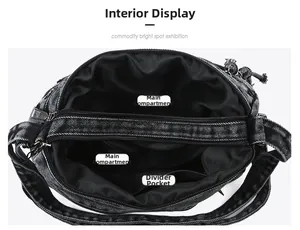 Interior view of black washed denim crossbody bag featuring two main compartments and zipper pocket