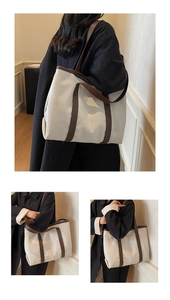 Détail du sac cabas en toile montrant les anses en cuir marron et la texture épaisse