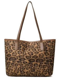 Close-up of leopard print canvas tote bag with premium brown leather handles and trim