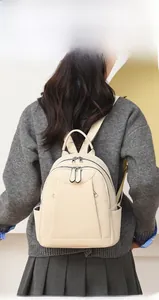 Model wearing a stylish leopard print backpack with silver zippers and side pockets