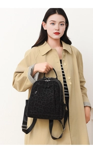 Close-up of leopard print backpack showing soft velvet texture and metal double zippers
