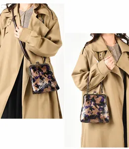 Detalle del bolso vintage floral con cierre metálico y correa ajustable al hombro