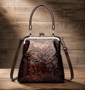 Detalle de bolso médico vintage rojo oscuro con rosas grabadas y cierre de oro viejo