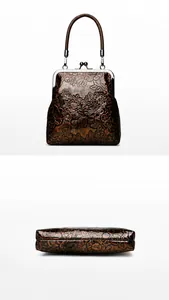 Detalle del bolso de cuero vintage con relieve floral que muestra la parte trasera y base