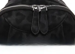 Detail of a leopard print backpack showing smooth dual silver zippers and textured fabric