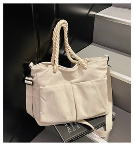 Detail of beige corduroy tote bag showing vertical rib texture and rope handles