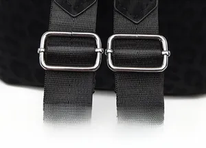 Detail of adjustable nylon shoulder straps with silver metal buckles on leopard print backpack