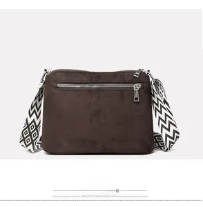 Rear view of brown nylon crossbody bag with silver zipper pocket and geometric strap