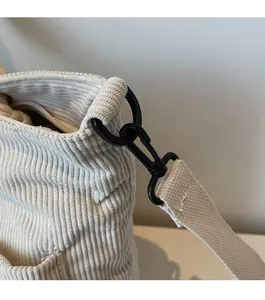 Detail of durable black hook connector and white woven strap on corduroy tote bag