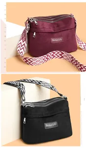 Detail of burgundy and black suede bags with ethnic geometric straps and multi-zipper layers