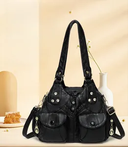 Close-up of soft black leather shoulder bag with functional multi-pockets and silver rivets