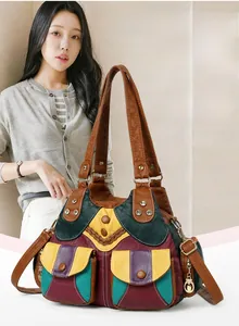 Detail of colorful patchwork leather handbag with vintage metal buckles and dual front pockets