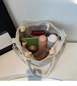 Beige corduroy tote bag showing spacious interior with water bottle and tablet