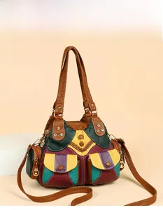 Detail of multi-color patchwork leather handbag with vintage metal rivets and front pockets