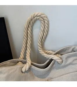 Detail of twisted cotton rope handle and metal eyelets on corduroy tote bag