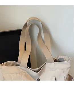 Close-up of beige tote bag showing high-quality nylon texture and wide woven shoulder strap