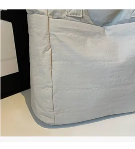 Macro view of soft grey nylon tote fabric with detailed parallel stitching textures