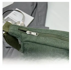 Détail du sac en velours côtelé vert foncé avec fermetures éclair métalliques