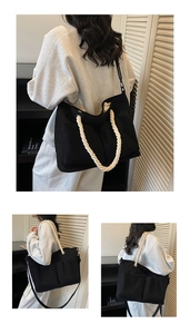 Detail of black corduroy tote bag featuring thick white cotton rope handles and dual pockets