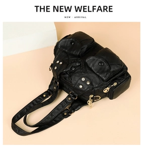 Detail of black multi-pocket soft leather handbag with gold hardware and rhinestone accents