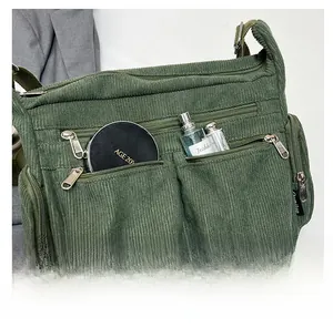 Détail d'un sac en velours côtelé vert armée montrant plusieurs poches et sa capacité