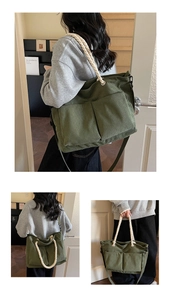 Detail of dark green corduroy tote bag with woven handles and adjustable crossbody strap