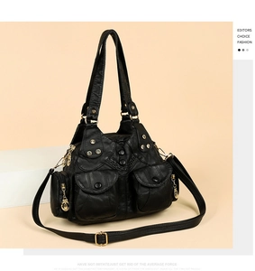 Detail view of a vintage black leather handbag with silver rivets and zippers