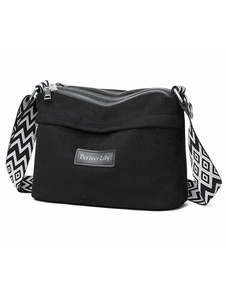 Detail view of black nylon pillow bag showing three zippers and wave pattern wide strap