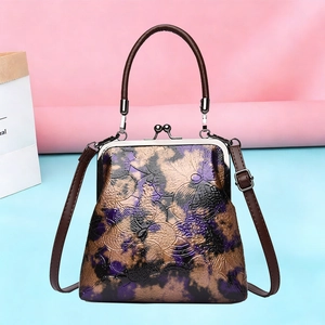 Bolso retro morado con relieve floral, cierre de marco metálico y asa superior elegante
