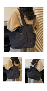 Detail of minimalist black nylon tote bag showing side pocket and brand logo patch