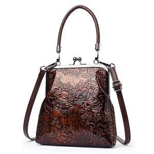 Bolso de mano retro con relieve floral y cierre de clip en color marrón oscuro