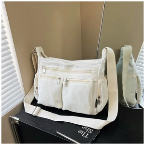 Détail du sac fourre-tout en velours côtelé beige avec poches zippées et bandoulière