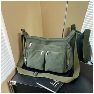 Détail du sac en velours côtelé vert avec trois poches zippées et large bandoulière en toile