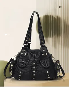 Detail of black washed leather tote bag with sparkling rhinestones and gold hardware studs