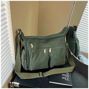 Détail du sac en velours côtelé vert armée avec plusieurs poches et large bandoulière