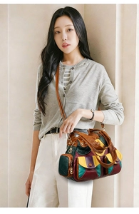 Detail of multi-color patchwork leather handbag with exterior pockets and metallic zipper