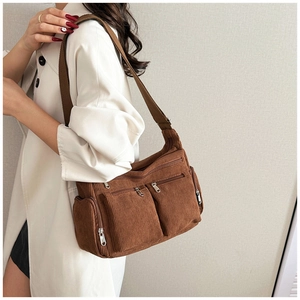 Détail du tissu en velours côtelé marron du sac bandoulière avec poches zippées