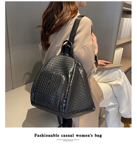 Detail of black woven texture and metal logo on a spacious vegan leather backpack