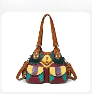 Detailed front view of a multi-color patchwork leather handbag with gold rivets and pockets