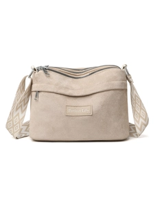 Detail of beige quilted shoulder bag featuring triple zippers and patterned woven strap