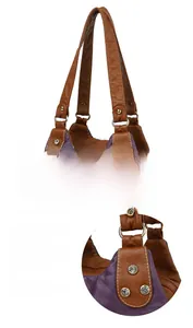 Detail of reinforced brown handles with gold metal rings and rhinestone rivets on tote