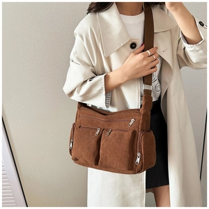 Détail du sac fourre-tout en velours côtelé marron foncé avec plusieurs poches zippées