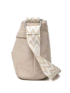 Detail of light beige pillow bag with wide wave-patterned knit shoulder strap and silver zip