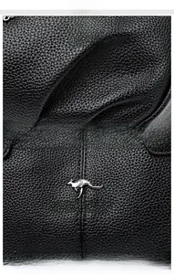 Dettaglio macro della texture in pelle nera e logo in metallo argento sulla borsa