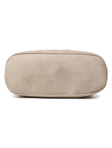 Detailed base view of the minimalist beige suede shoulder bag with clean oval stitching